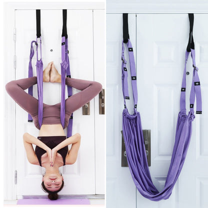 A person using a purple yoga inversion and stretching strap to assist with a yoga pose, hanging from a door frame.