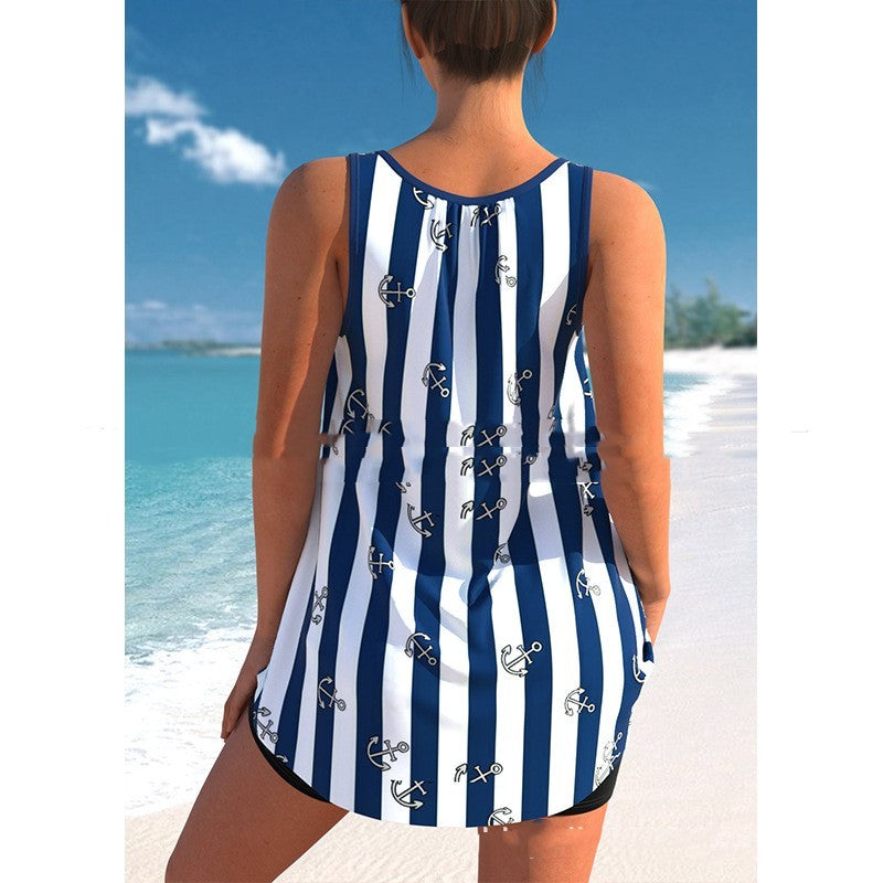 Person wearing a blue and white striped swimsuit with anchor patterns on a beach.