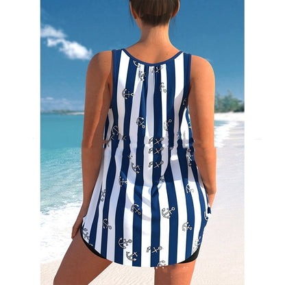 Person wearing a blue and white striped swimsuit with anchor patterns on a beach.
