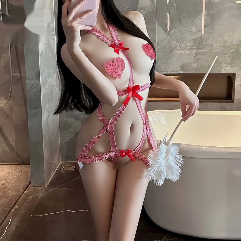 The image showcases a playful and seductive red jumpsuit lingerie featuring a low-cut design with heart patterns and bow accents. The model is seen holding a white feather duster, adding a game-like element to the presentation.