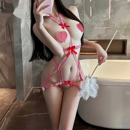 The image showcases a playful and seductive red jumpsuit lingerie featuring a low-cut design with heart patterns and bow accents. The model is seen holding a white feather duster, adding a game-like element to the presentation.