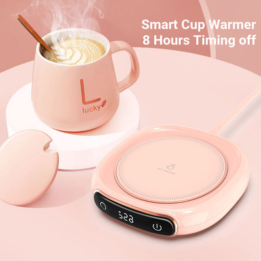 A beige coffee mug warmer with a digital timer display on the front, alongside a steaming mug resting on top and a lid.