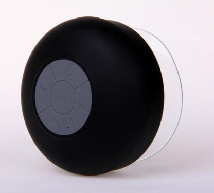 A black mini waterproof Bluetooth speaker with a suction cup and control buttons on the top.