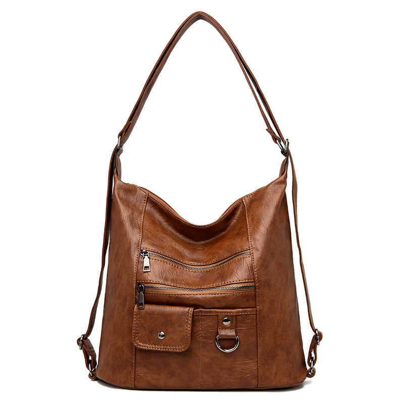 A brown soft leather diagonal shoulder bag with a zipper closure and double roots.