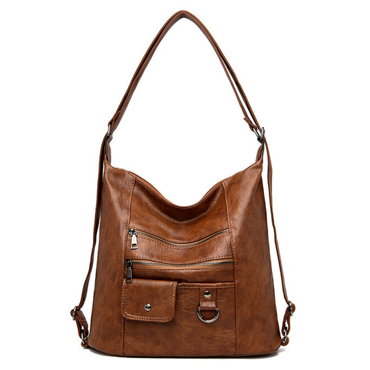 A brown soft leather diagonal shoulder bag with a zipper closure and double roots.