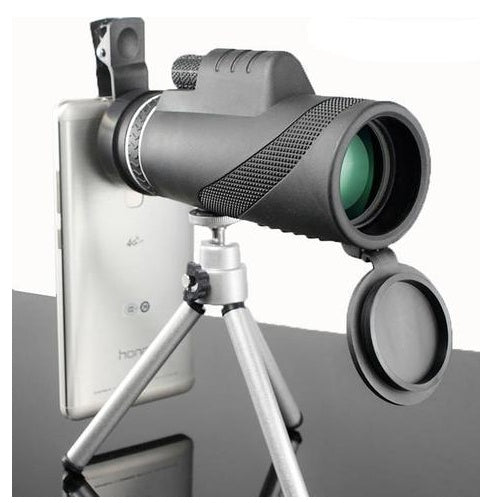 A black monocular with zoom lens attached to a silver smartphone using a clip, mounted on a tripod.
