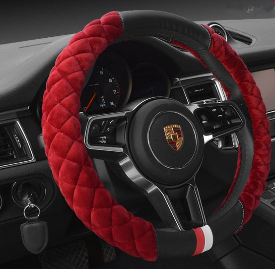 Steering wheel cover with red quilted design on a car dashboard.