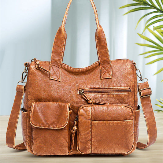 A brown, faux leather shoulder bag with multiple compartments and a textured surface.