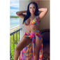 A woman wearing a multicolored geometric patterned three-piece bikini swimwear with a matching cover-up skirt.