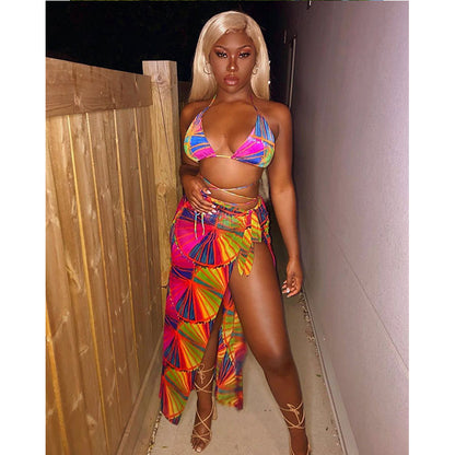 Person wearing a colorful bikini and skirt set in a narrow hallway.