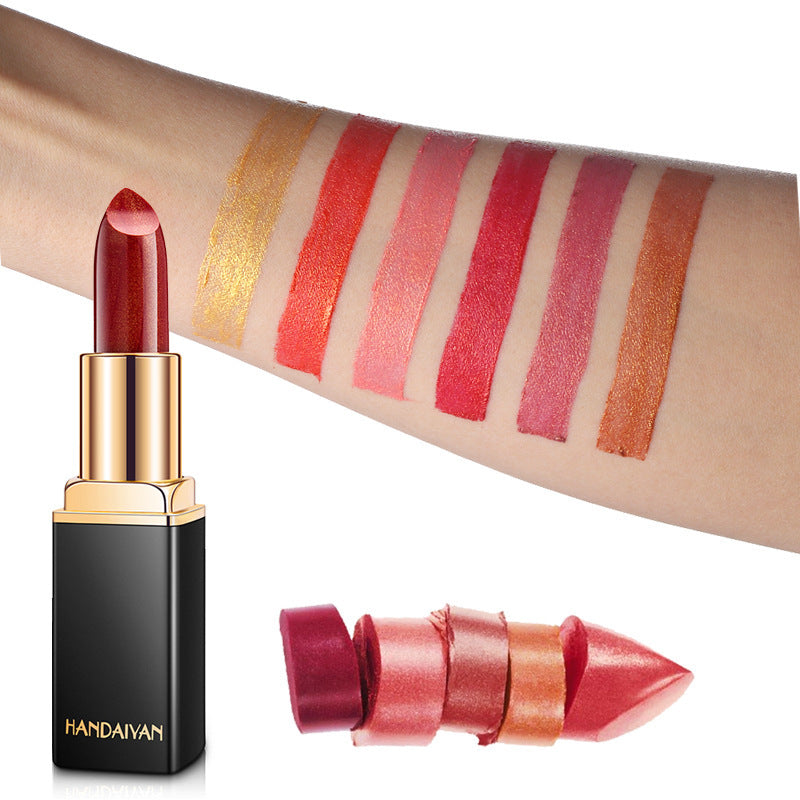 A swatch of various metallic red lipsticks on an arm, with the corresponding lipsticks displayed in a line below.