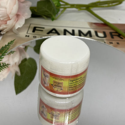 Two white jars with labels on a reflective surface.
