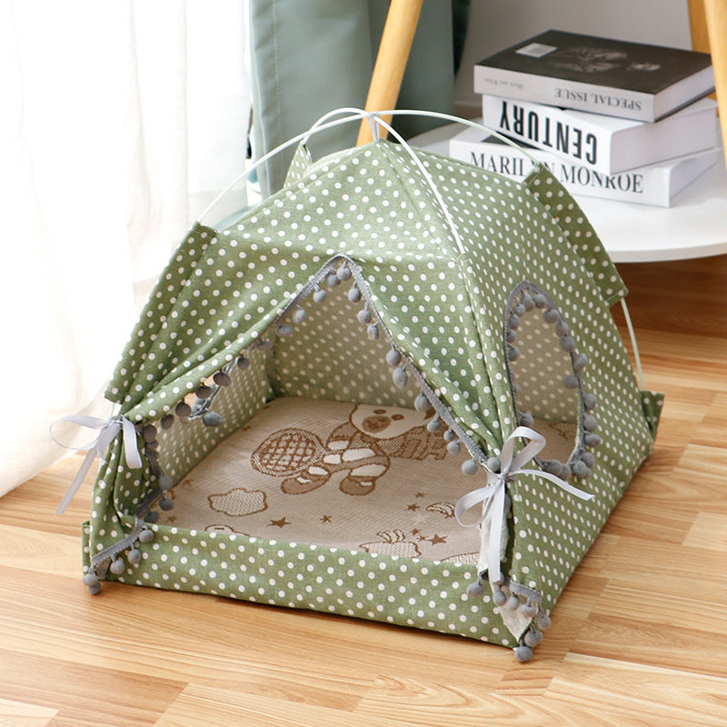 A green pet tent made of fabric, set up on the floor with a patterned interior.