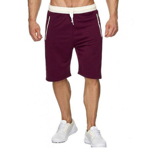 A pair of men's casual shorts in purple color with a white drawstring and white stripes on the legs. The shorts are paired with white sneakers.
