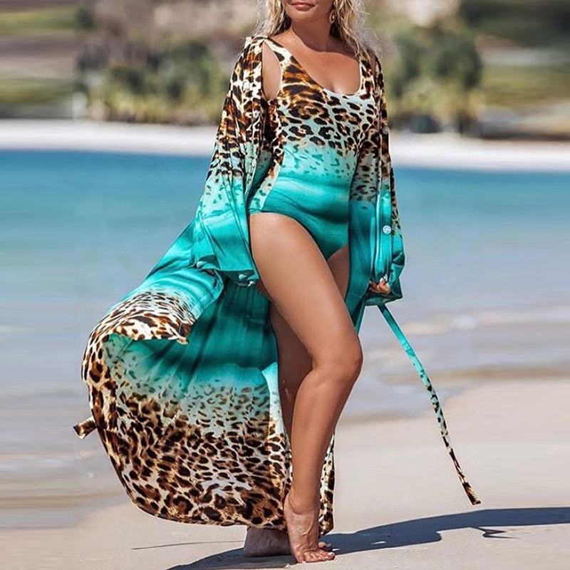 A woman wearing a green and leopard print swimwear cover-up at the beach