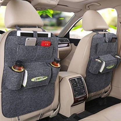 A multi-pocket auto seat organizer bag attached to the back of a car seat, featuring various pockets holding items like bottles and a remote control.