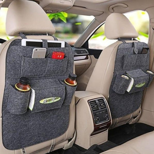 A multi-pocket auto seat organizer bag attached to the back of a car seat, featuring various pockets holding items like bottles and a remote control.