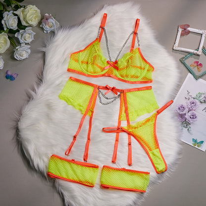 A woman modeling a pink lingerie set which includes a bra, panties, and garter straps.