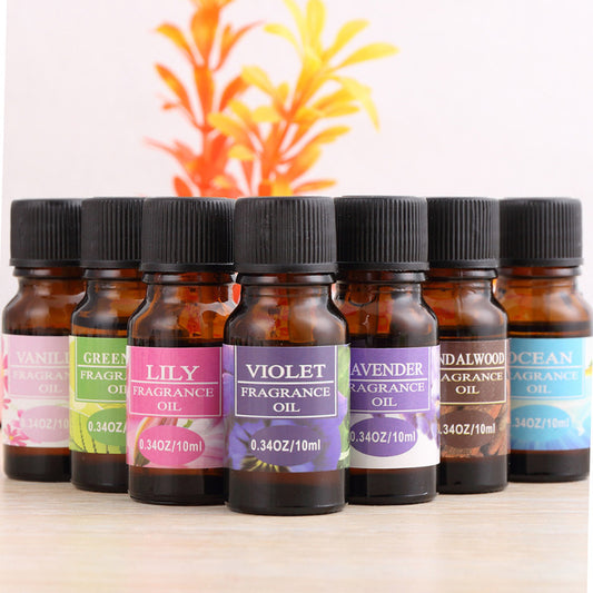 A series of small glass bottles labeled with different names such as 'LILY', 'VIOLET', 'LAVENDER', 'SANDALWOOD', 'CHERRY BLOSSOM', 'CEA', 'GREEN TEA', 'OCEAN', 'VANILLA', 'OSMANthus', 'SWEET', 'JASMINE', indicating various fragrance oils.