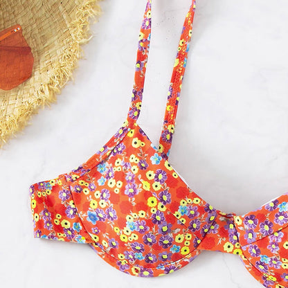 Floral bikini top on a white background with a straw hat.