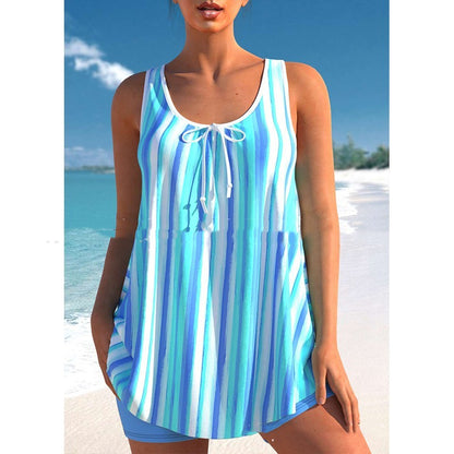 Woman wearing a blue and white striped tank top on a beach.