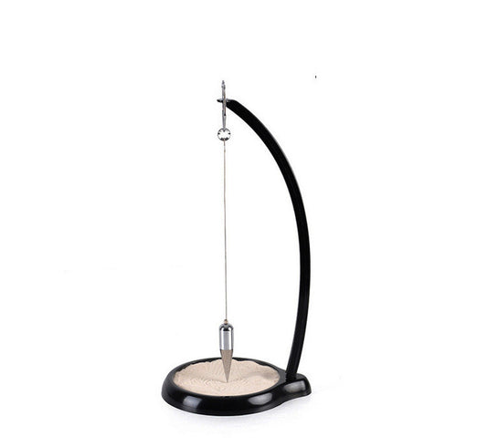 A black and beige gravity sand swing sand table with a pendulum.