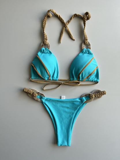 A solid color lace-up bikini swimsuit in dark blue with light blue trim and a geometric pattern on the straps.