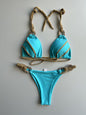 A solid color lace-up bikini swimsuit in dark blue with light blue trim and a geometric pattern on the straps.