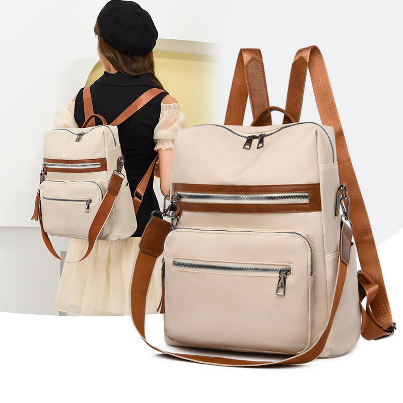 A beige and brown women's backpack with a large capacity, multiple compartments, and a zipper closure. It is shown from the front and side, with a person wearing it in the background.