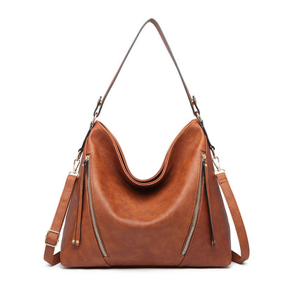 A brown, faux leather handbag with a shoulder strap, external pocket zippers, and a bucket shape design.