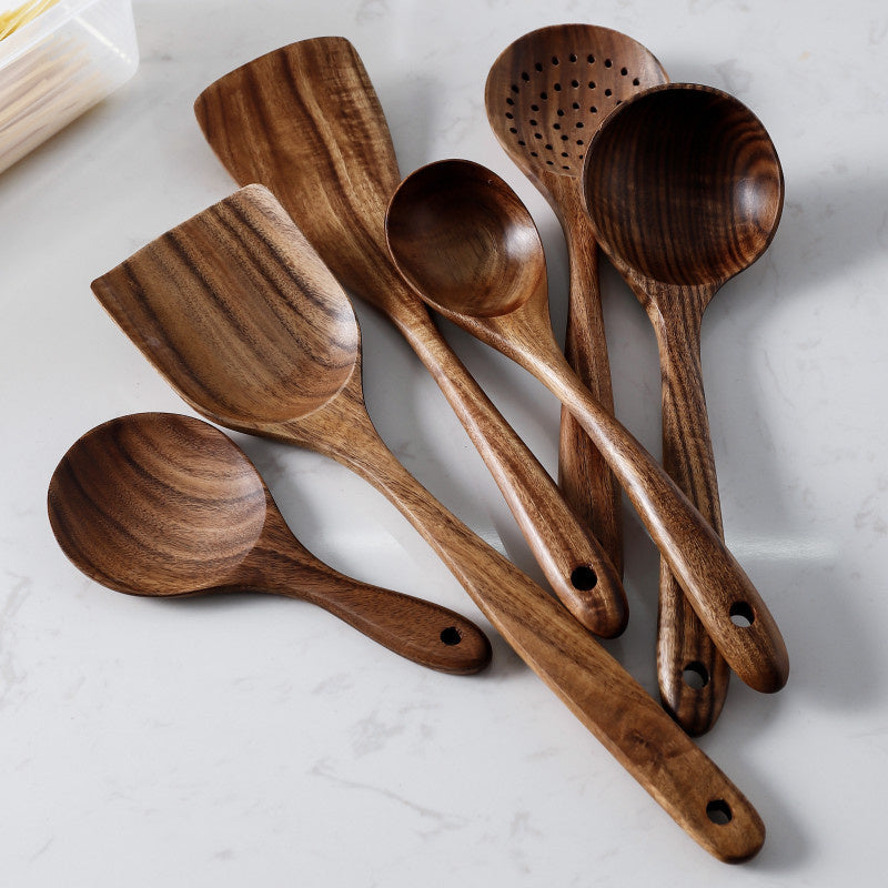 Set of wooden cooking utensils on a marble surface