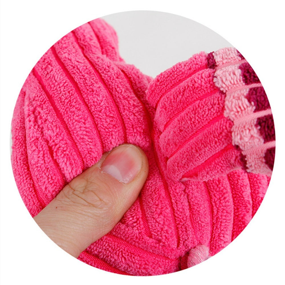 Pink textured scrubber held by a thumb against a white background