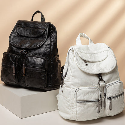 Two large-capacity backpacks, one black and one white, with multiple pockets and locks, displayed on a white pedestal.
