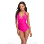 A woman wearing a red halterneck one-piece swimsuit with lace-up details at the front.