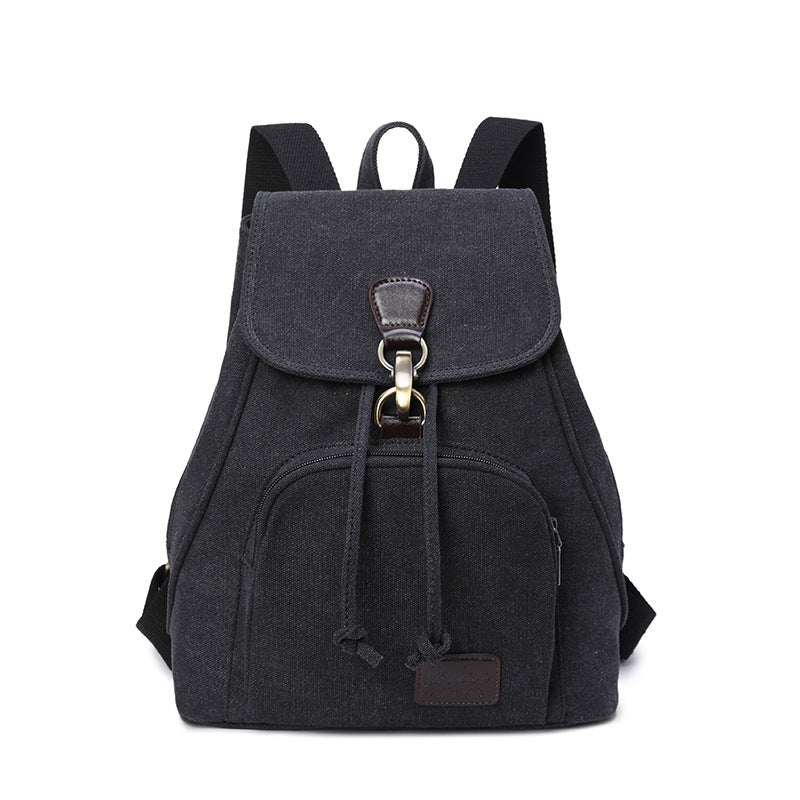 A black canvas rucksack with a front pocket and a draw buckle, featuring a solid pattern and a bucket shape.