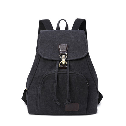 A black canvas rucksack with a front pocket and a draw buckle, featuring a solid pattern and a bucket shape.