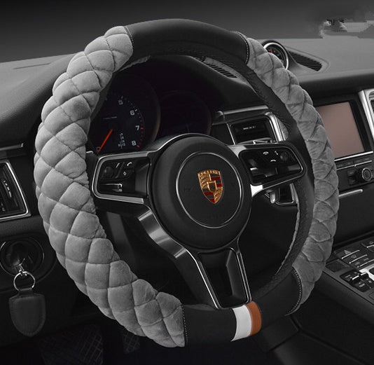 Steering wheel cover with gray quilted design on a car steering wheel.