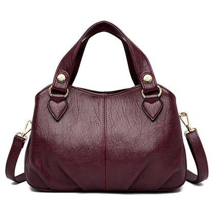 A wine red multifunctional handbag with sheepskin stitching, featuring a soft leather exterior and a shoulder strap.