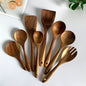 Set of wooden kitchen utensils on a white surface