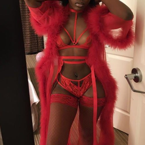 A person wearing a red lingerie set that includes a long skirt, lingerie top, and matching lingerie bra.