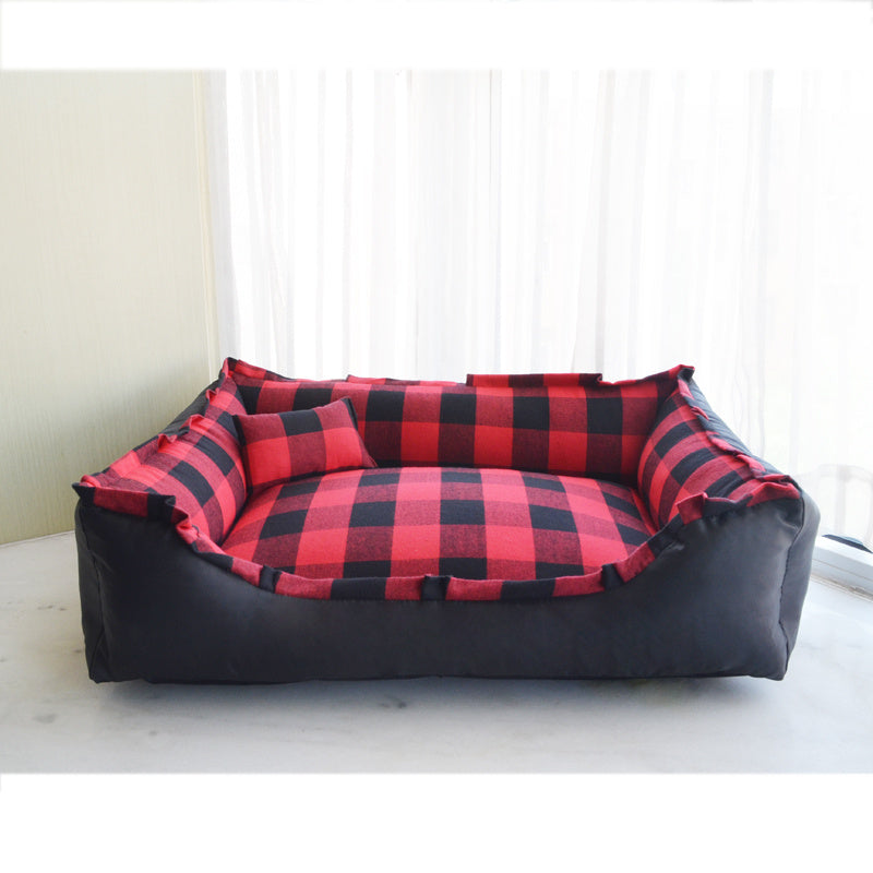 A small dog bed with a red and black plaid pattern on a white background.