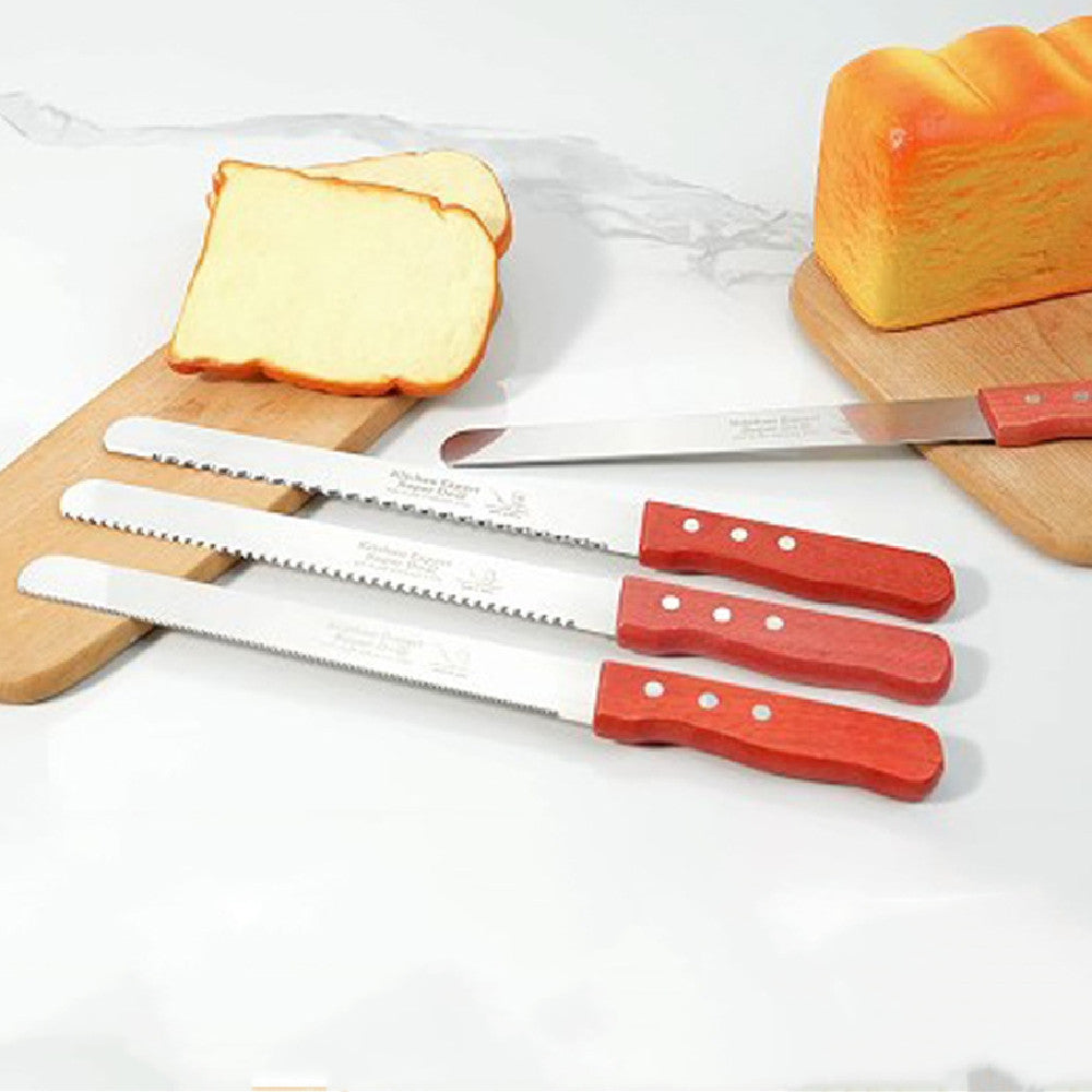 Three stainless-steel bread knives with red wooden handles, displayed on a kitchen counter with sliced bread in the background.