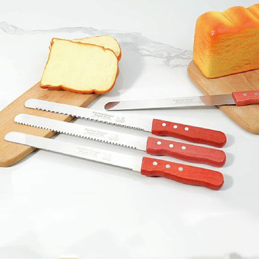 Three stainless-steel bread knives with red wooden handles, displayed on a kitchen counter with sliced bread in the background.
