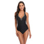 A woman wearing a red halterneck one-piece swimsuit with lace-up details at the front.