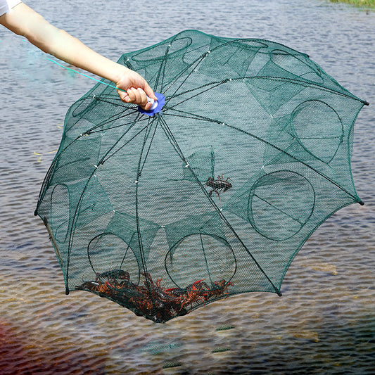 A person holding an automatic folding fishing umbrella net, with the net partially opened and showing the mesh structure, over a body of water.