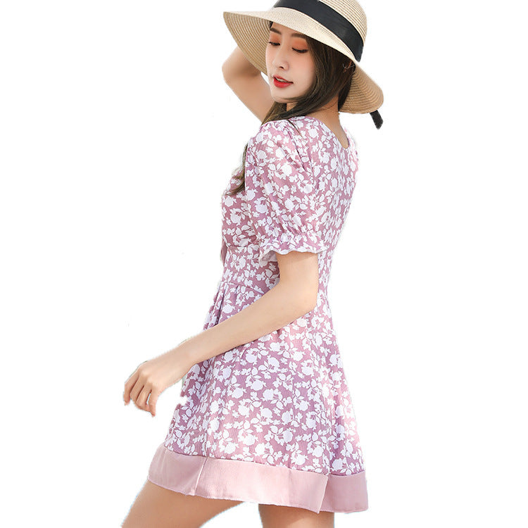 Woman in a floral dress and sun hat on a white background