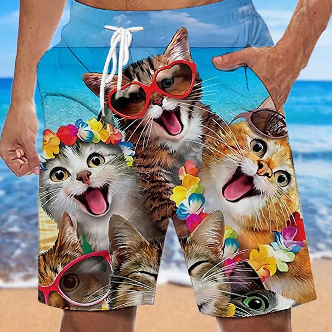 A pair of beach shorts with a printed design featuring multiple cats with colorful flowers and sunglasses.