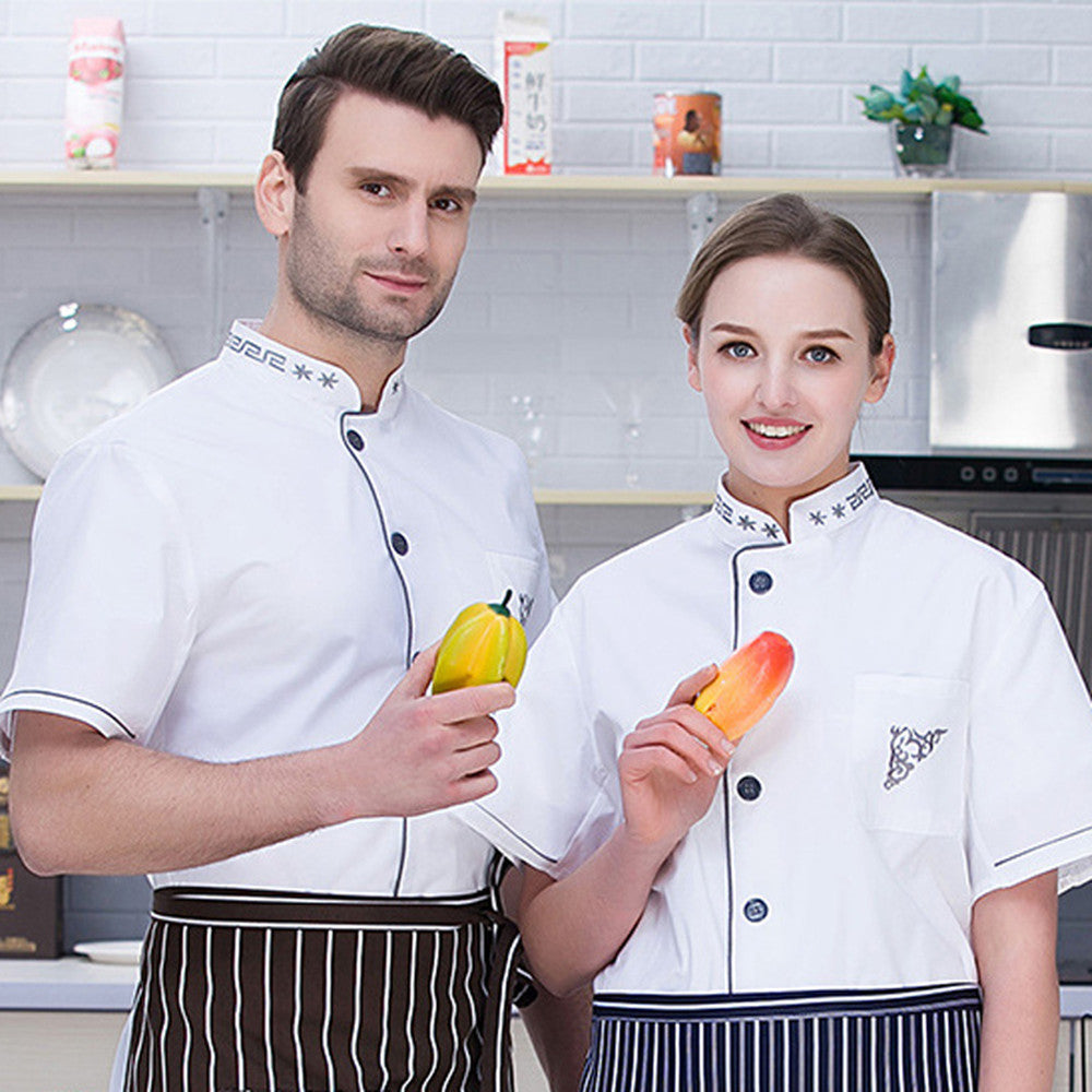 A male and a female chef wearing white short-sleeved chef uniforms with a gray border, standing in a kitchen setting.