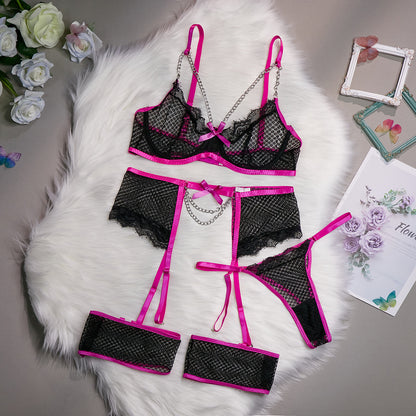A woman modeling a pink lingerie set which includes a bra, panties, and garter straps.