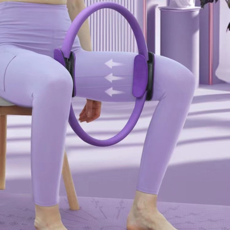 Person using a purple exercise hoop while sitting on a chair.